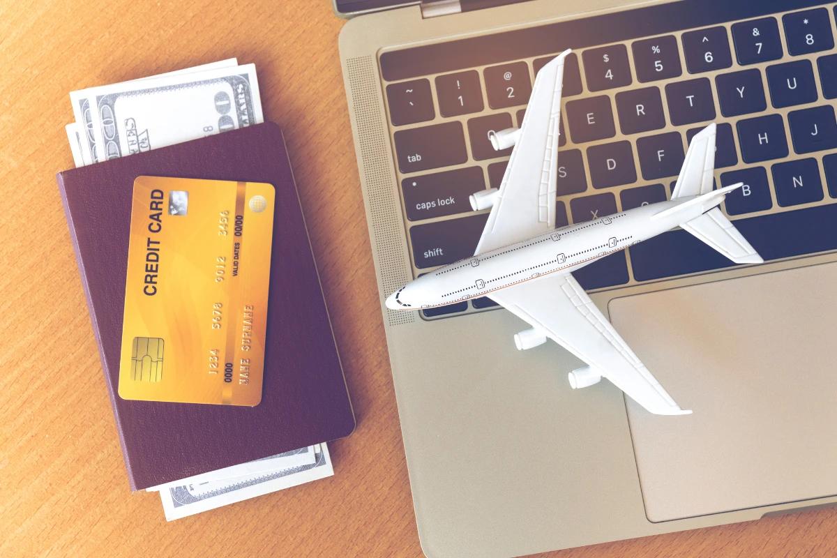 Travel Cards vs. Cash: What Works Best for Currency Exchange? 5 Travel cards, passports, and a compass on a colorful world map - the perfect setup for international currency exchange and planning.